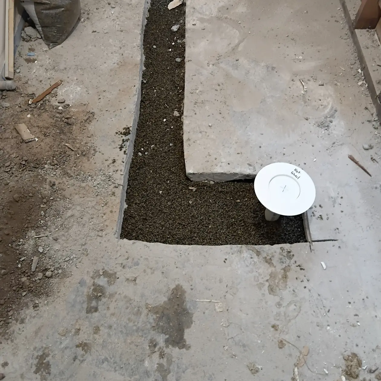 Concrete floor cut open to expose and repair a drain line